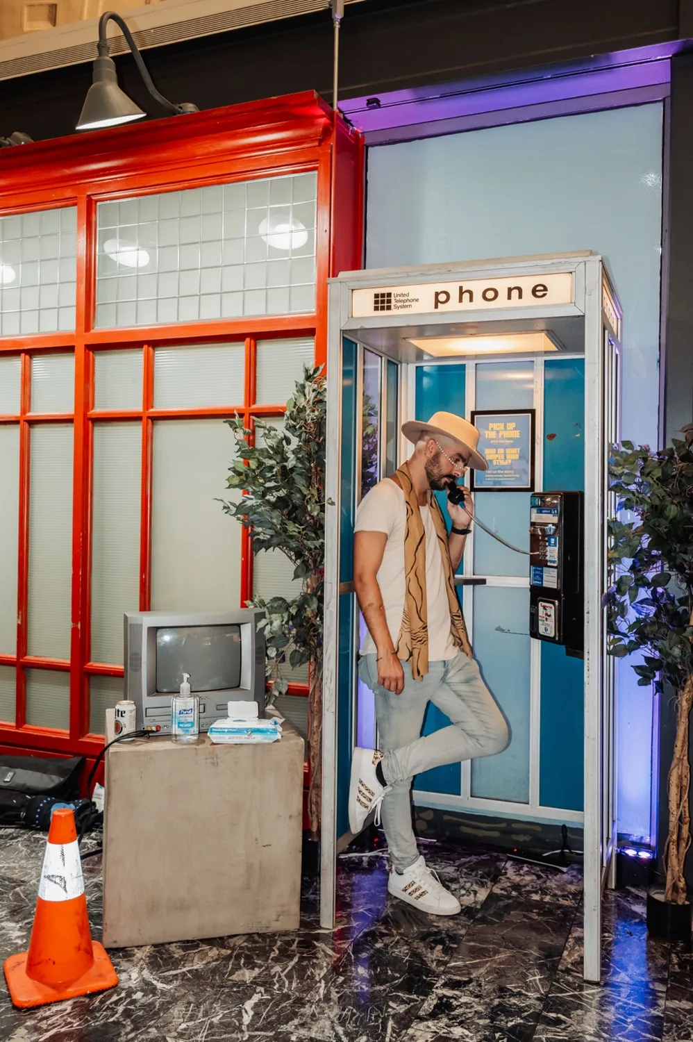 Visitor using a vintage payphone inside a converted booth